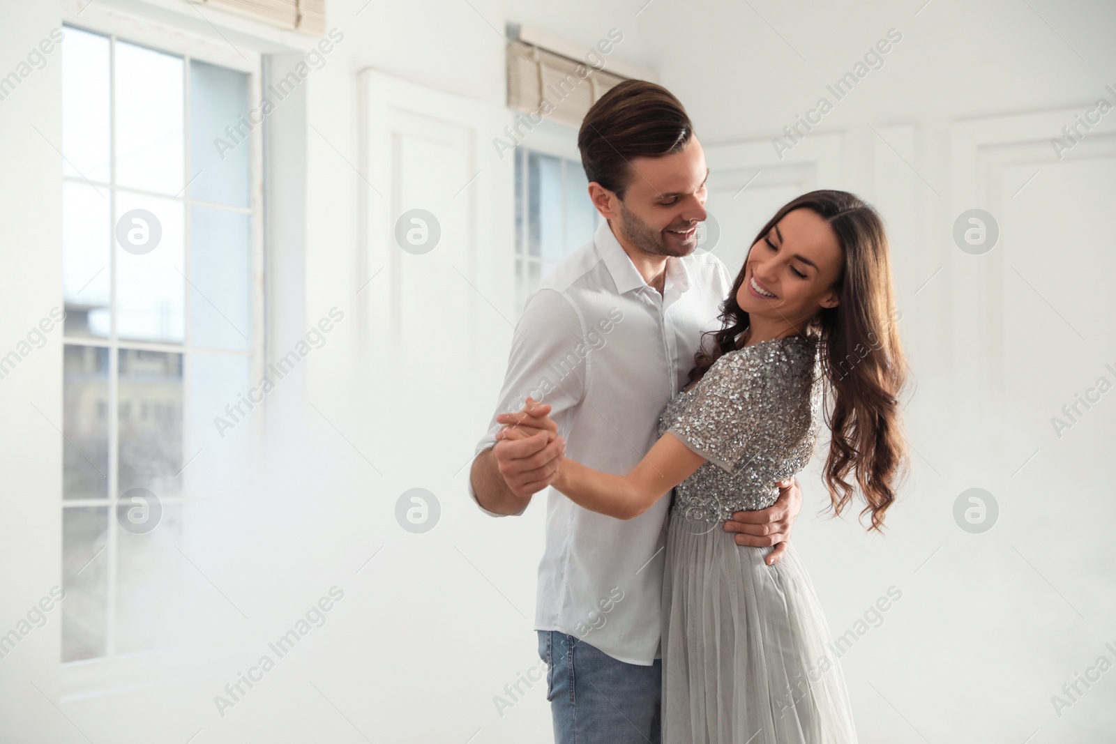 Photo of Lovely young couple dancing together in ballroom. Space for text