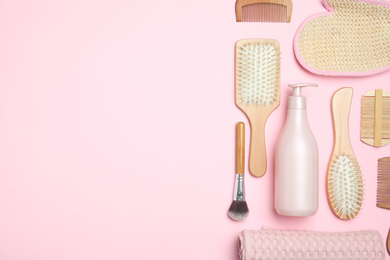 Flat lay composition with modern hair combs and brushes on pink background. Space for text