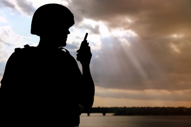 Photo of Soldier with portable radio transmitter outdoors. Military service