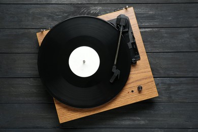 Photo of Turntable with vinyl record on black wooden background, top view