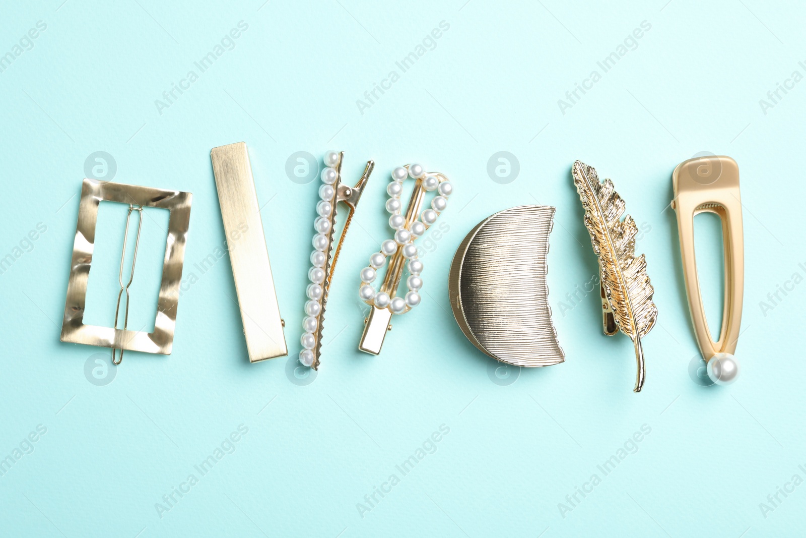 Photo of Stylish hair clips on light blue background, flat lay