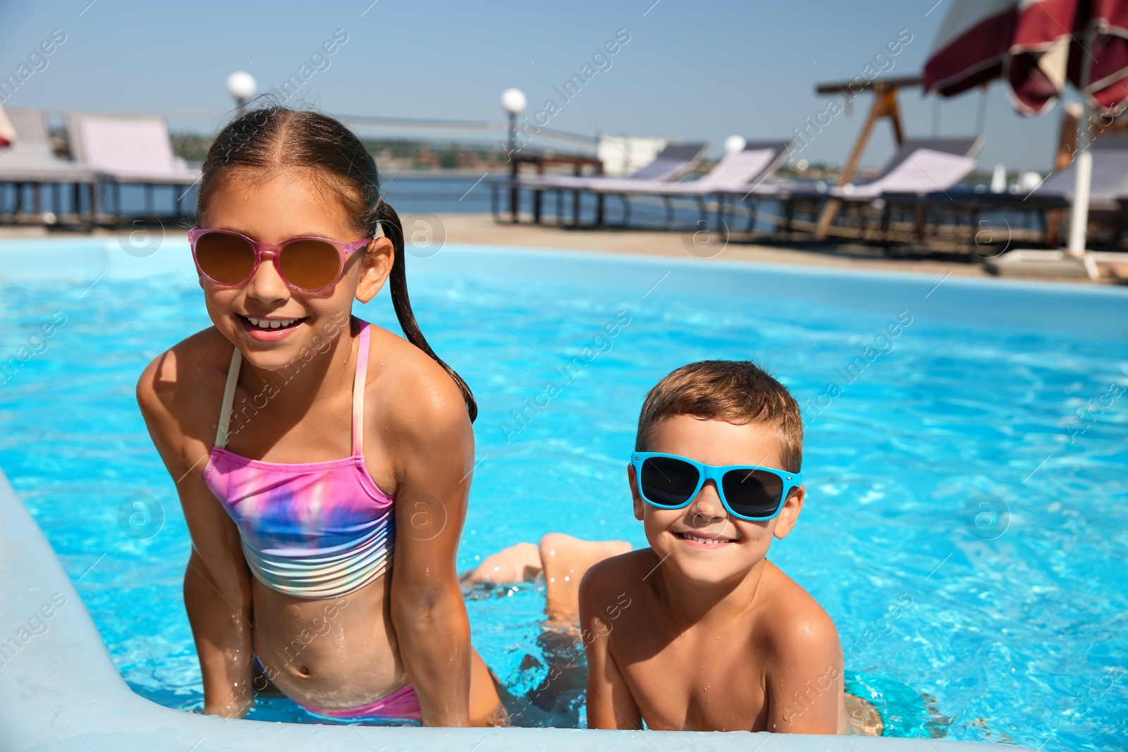 Photo of Happy children in swimming pool on sunny day