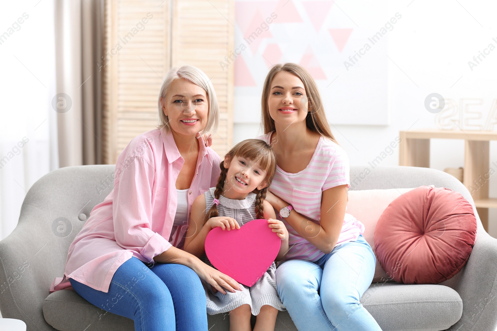 Photo of Beautiful mature lady, daughter and grandchild with gift box at home. Happy Women's Day