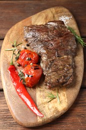 Photo of Delicious roasted beef meat, vegetables and spices on wooden table