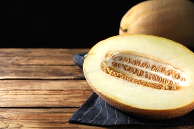 Photo of Delicious honey melon on wooden table, space for text
