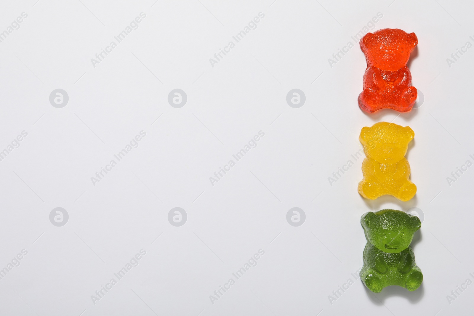 Photo of Delicious gummy bear candies on white background, top view