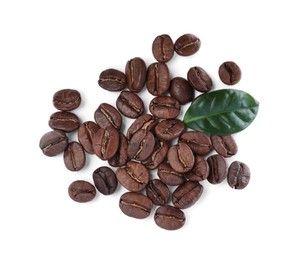 Photo of Pile of roasted coffee beans with fresh leaf on white background, top view