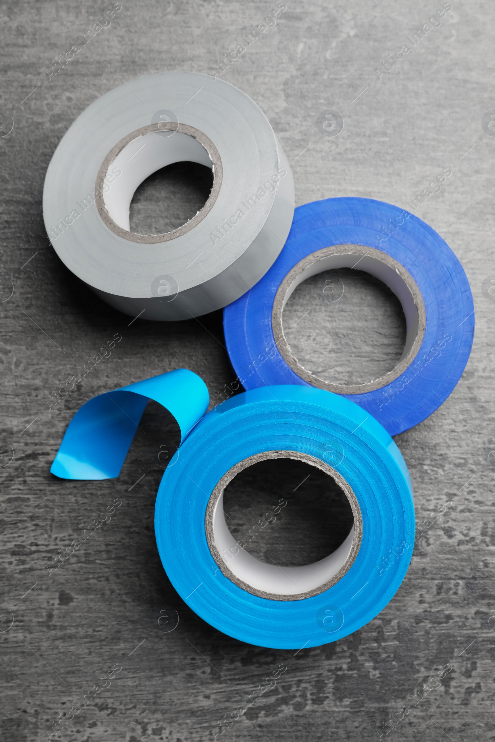 Photo of Colorful insulating tapes on dark gray background, flat lay