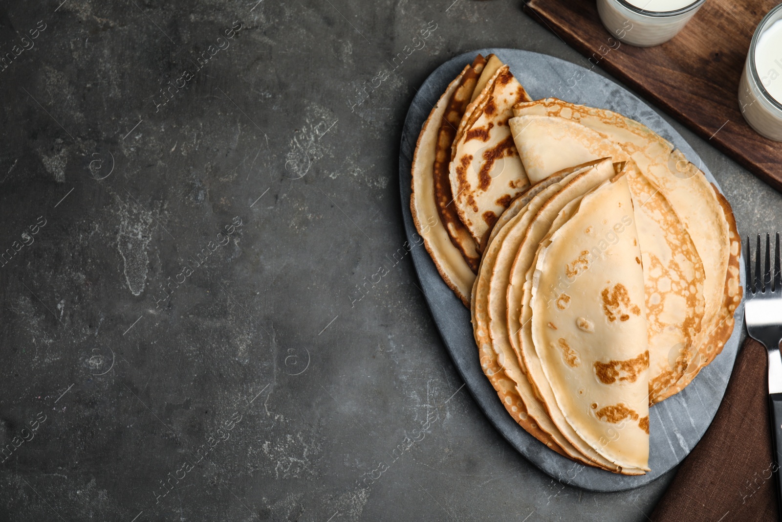 Photo of Flat lay composition with fresh thin pancakes on grey table. Space for text