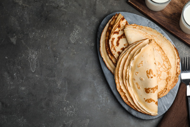 Photo of Flat lay composition with fresh thin pancakes on grey table. Space for text