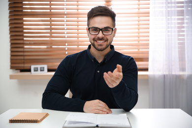 Photo of Happy man using video chat in modern office, view from web camera