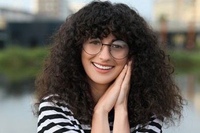 Photo of Portrait of beautiful woman in glasses outdoors. Attractive lady smiling and looking into camera