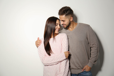 Image of Lovely couple in warm sweaters on light background 