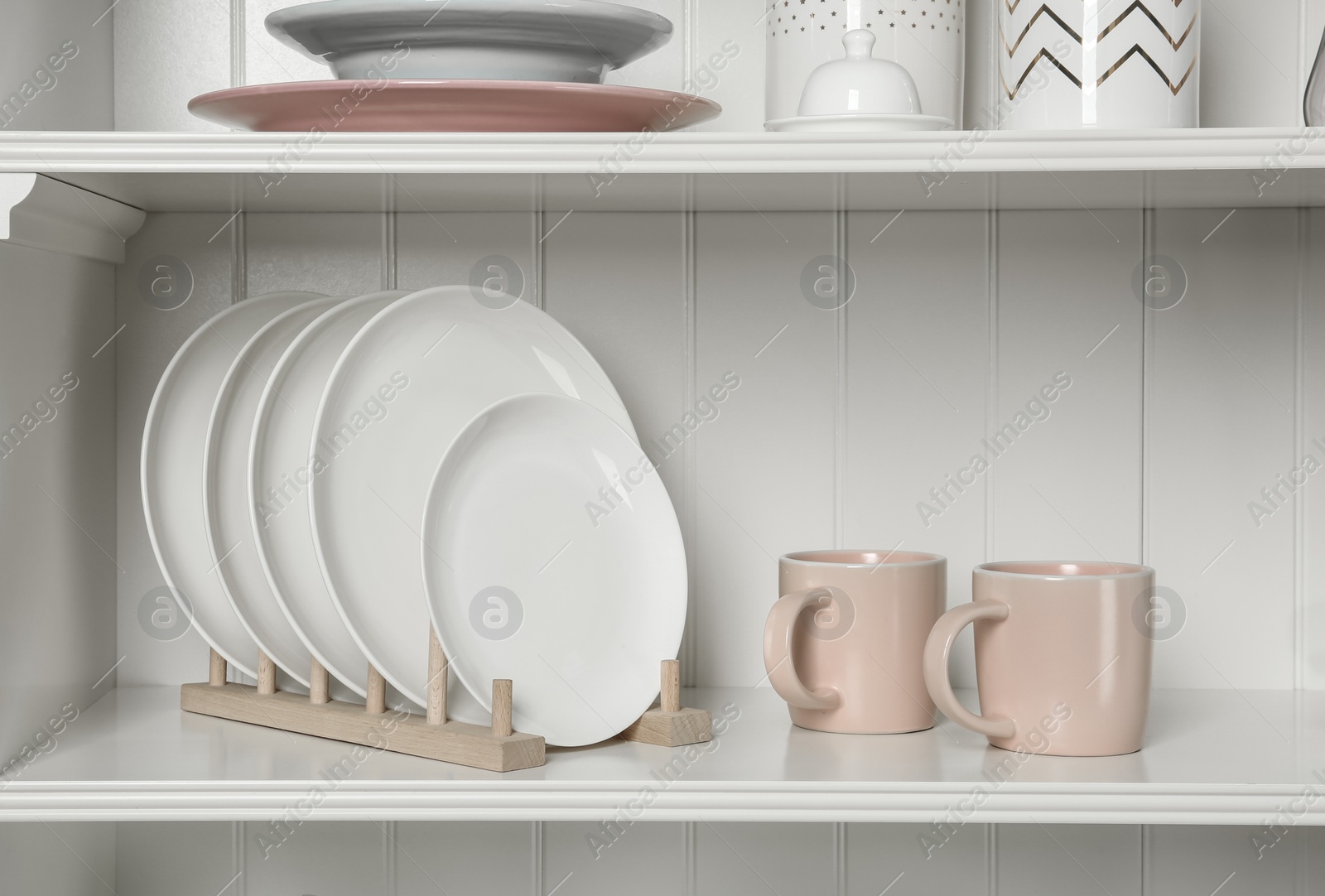 Photo of White shelving unit with set of dishware