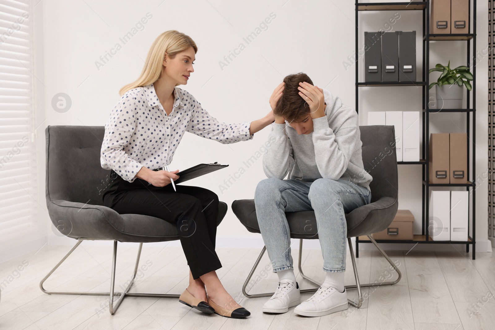 Photo of Psychologist working with teenage boy in office