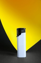 Stylish small pocket lighter on color background