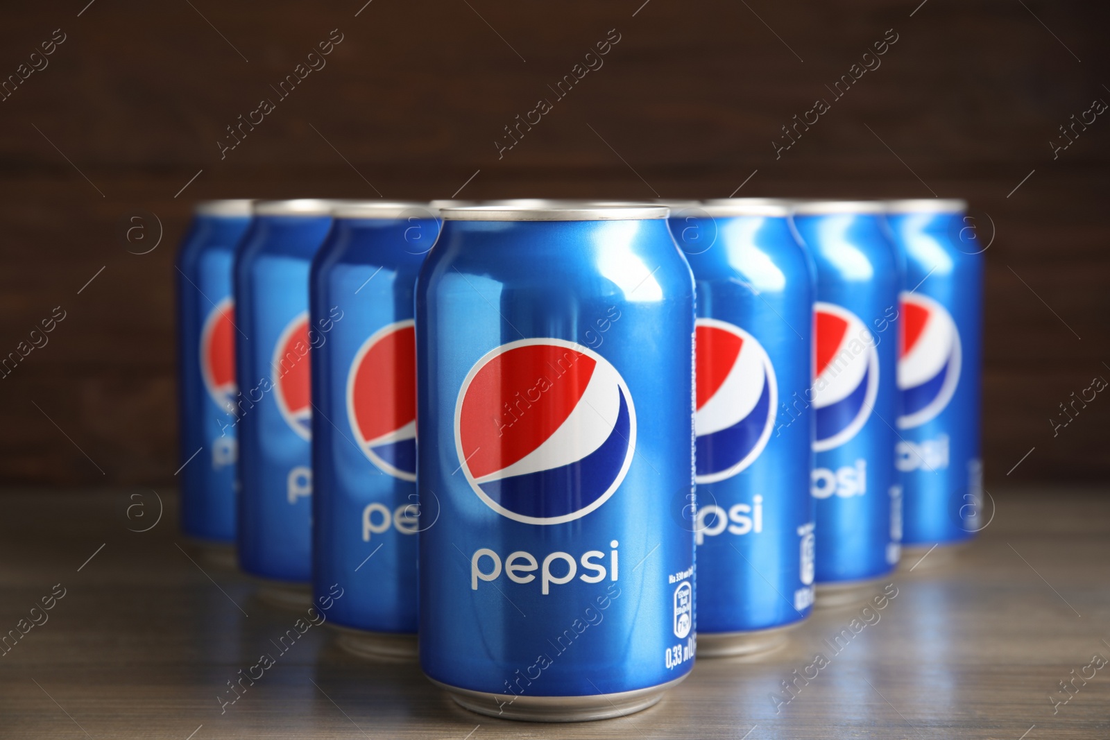 Photo of MYKOLAIV, UKRAINE - FEBRUARY 9, 2021: Many cans of Pepsi on wooden table
