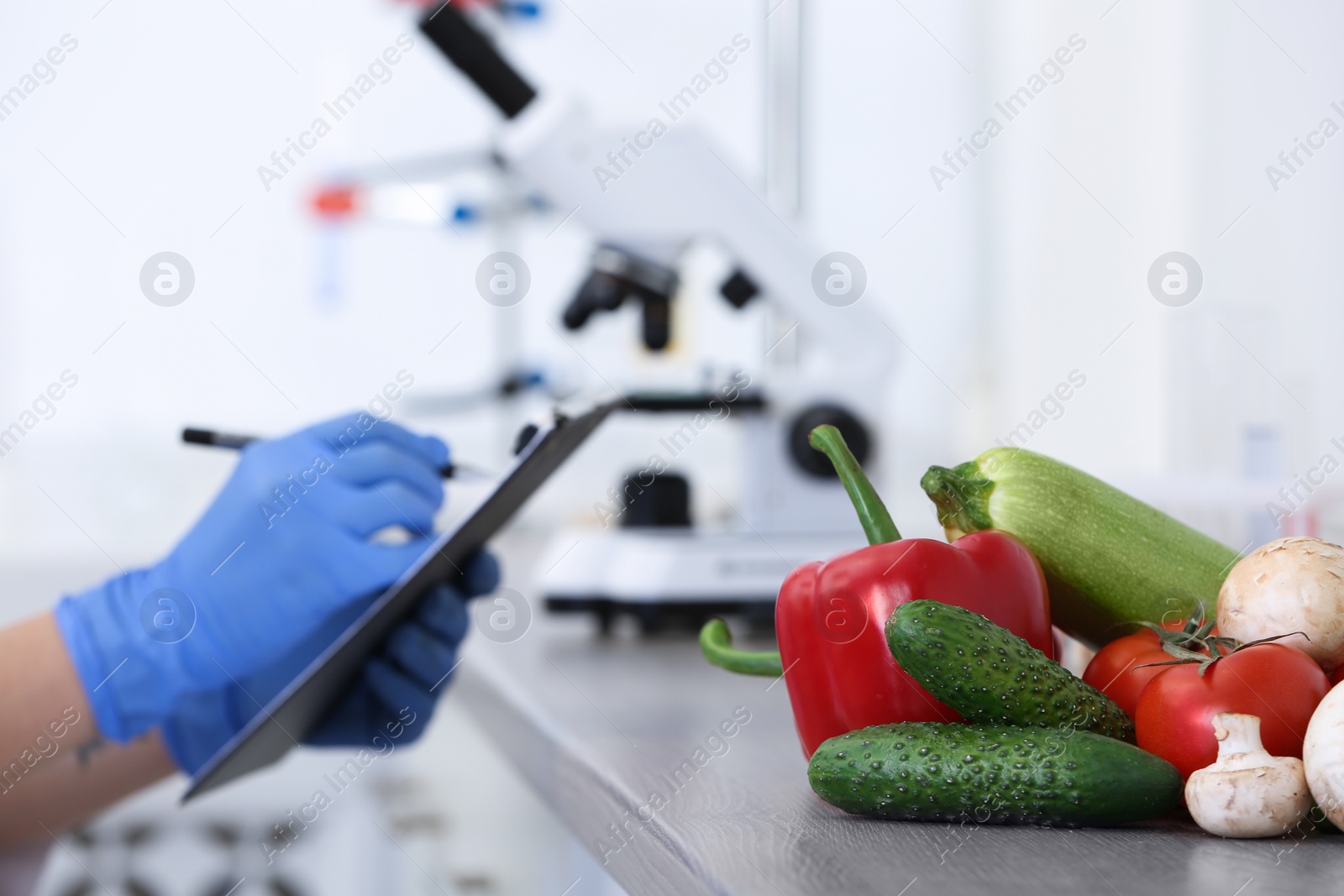 Photo of Fresh vegetables on table, scientist proceeding quality control in laboratory