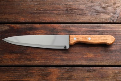 Photo of One sharp knife on wooden table, top view