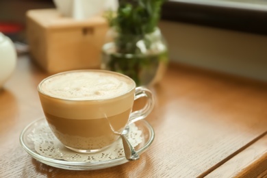 Cup of delicious aromatic coffee on table