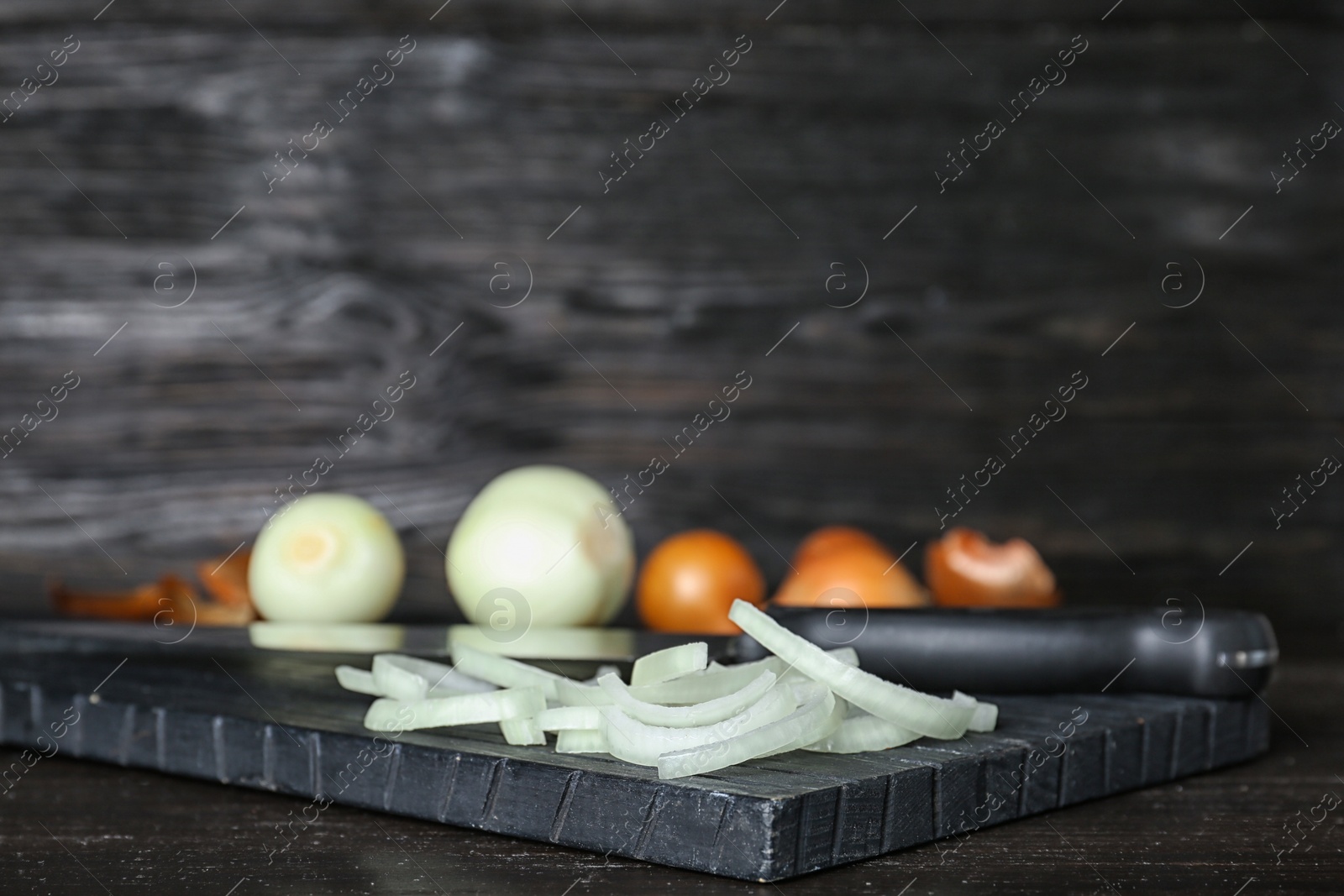 Photo of Wooden board with fresh sliced onion on table