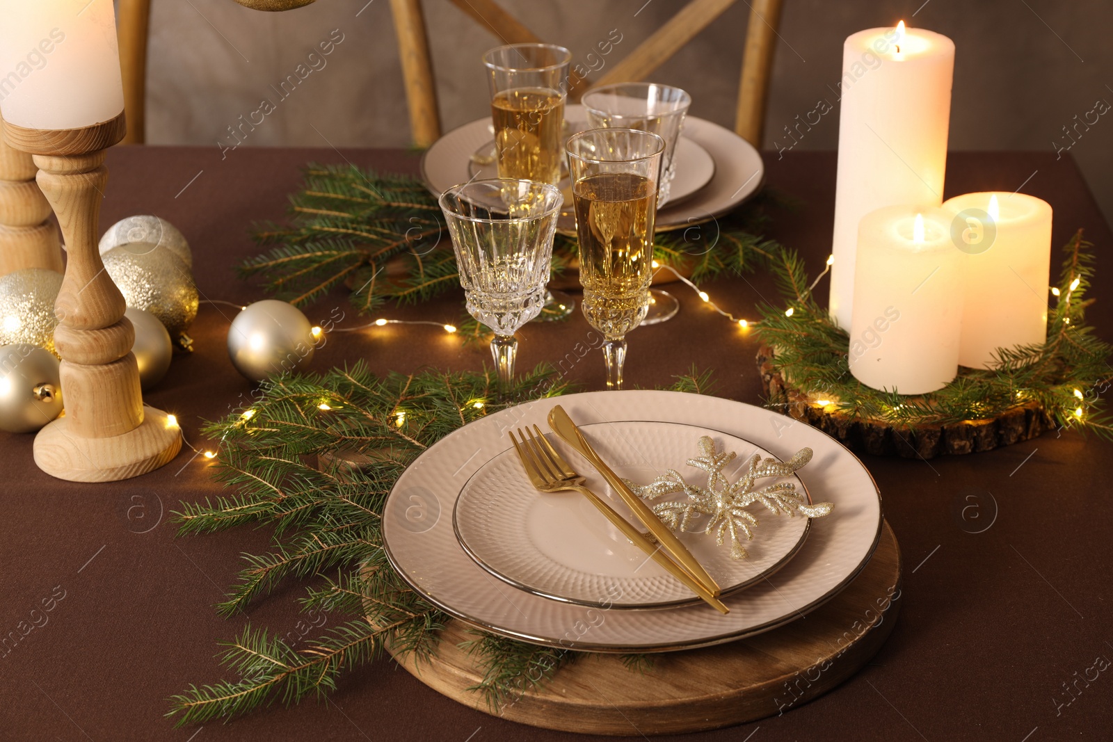 Photo of Christmas table setting with burning candles and festive decor