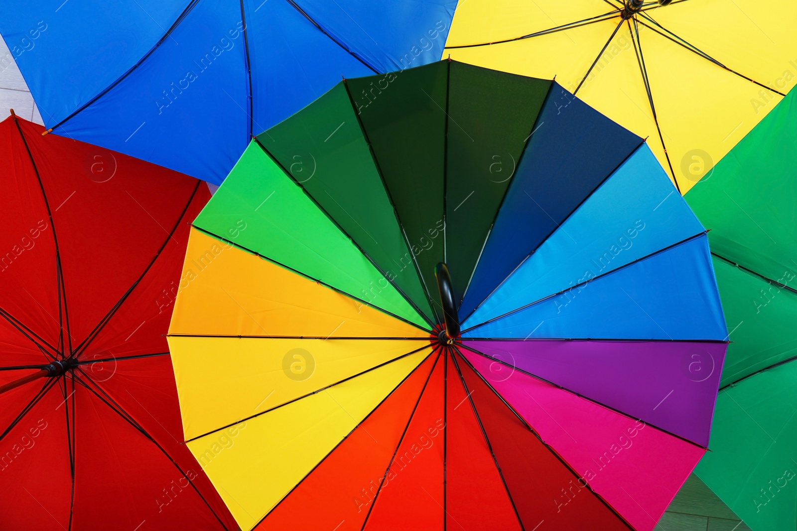 Photo of Many stylish colorful umbrellas as background, closeup