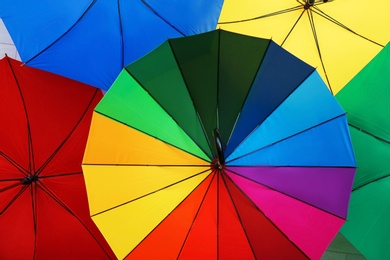 Photo of Many stylish colorful umbrellas as background, closeup