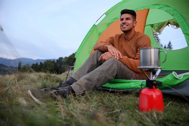 Photo of Man enjoying mountain landscape in camping tent