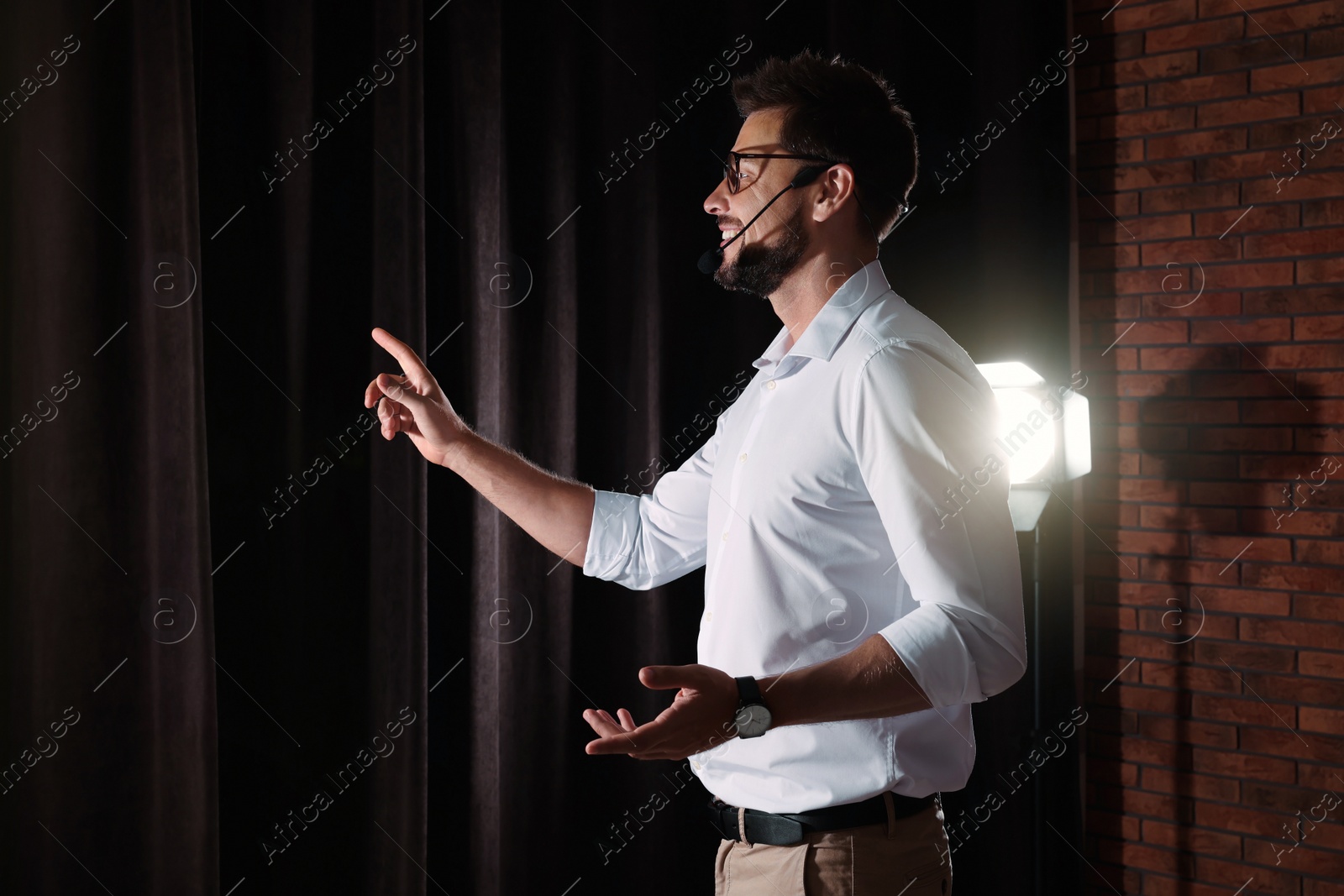 Photo of Motivational speaker with headset performing on stage