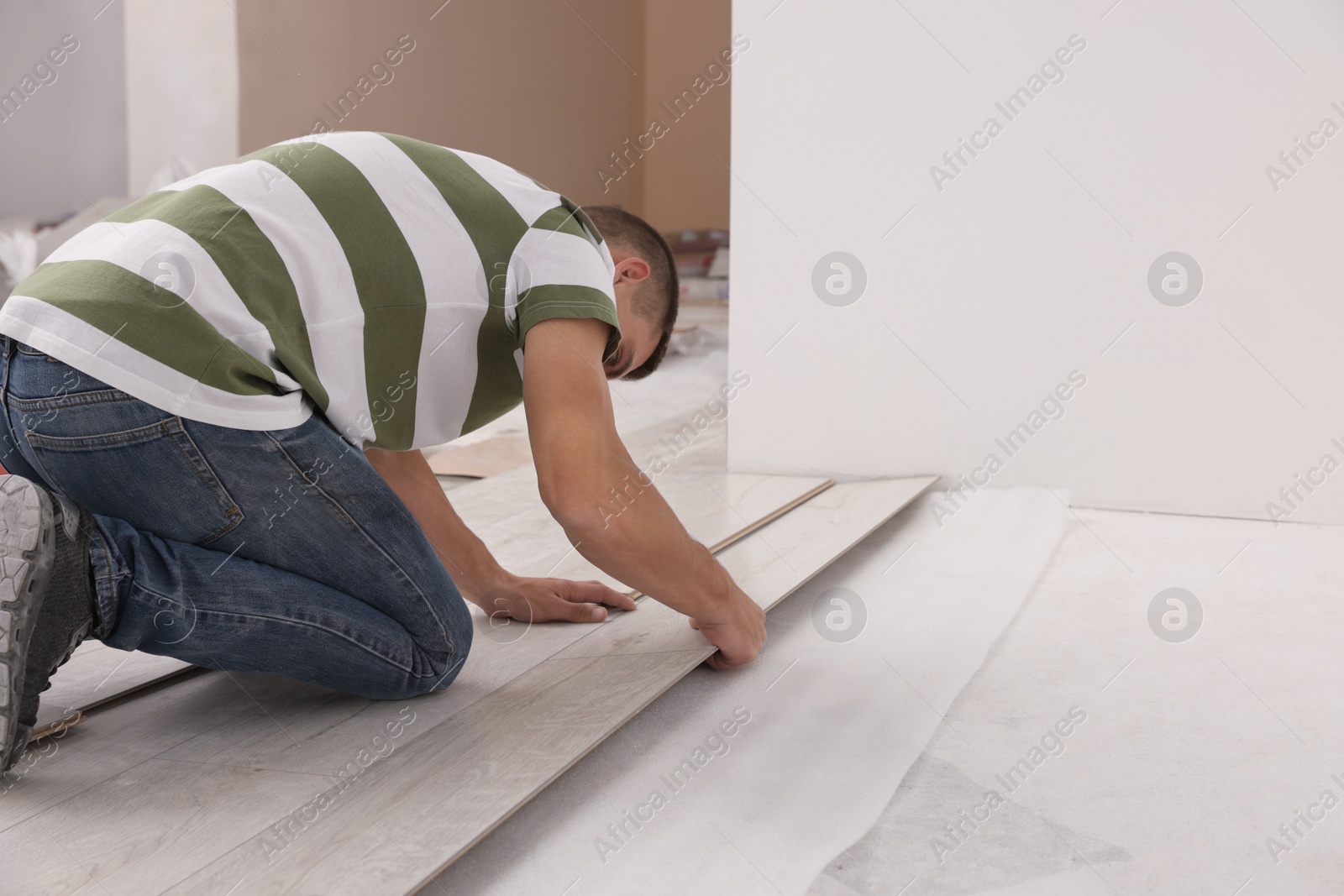 Photo of Professional worker installing new laminate flooring indoors