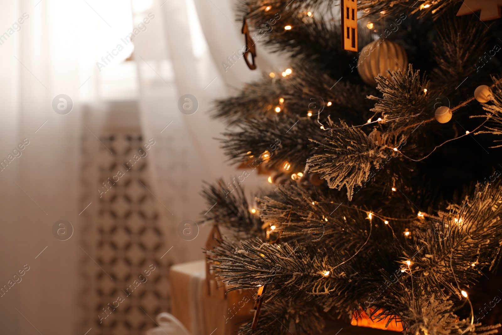 Photo of Beautiful decorated Christmas tree with fairy lights in room, closeup