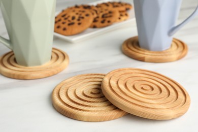 Photo of Stylish wooden cup coasters on white table