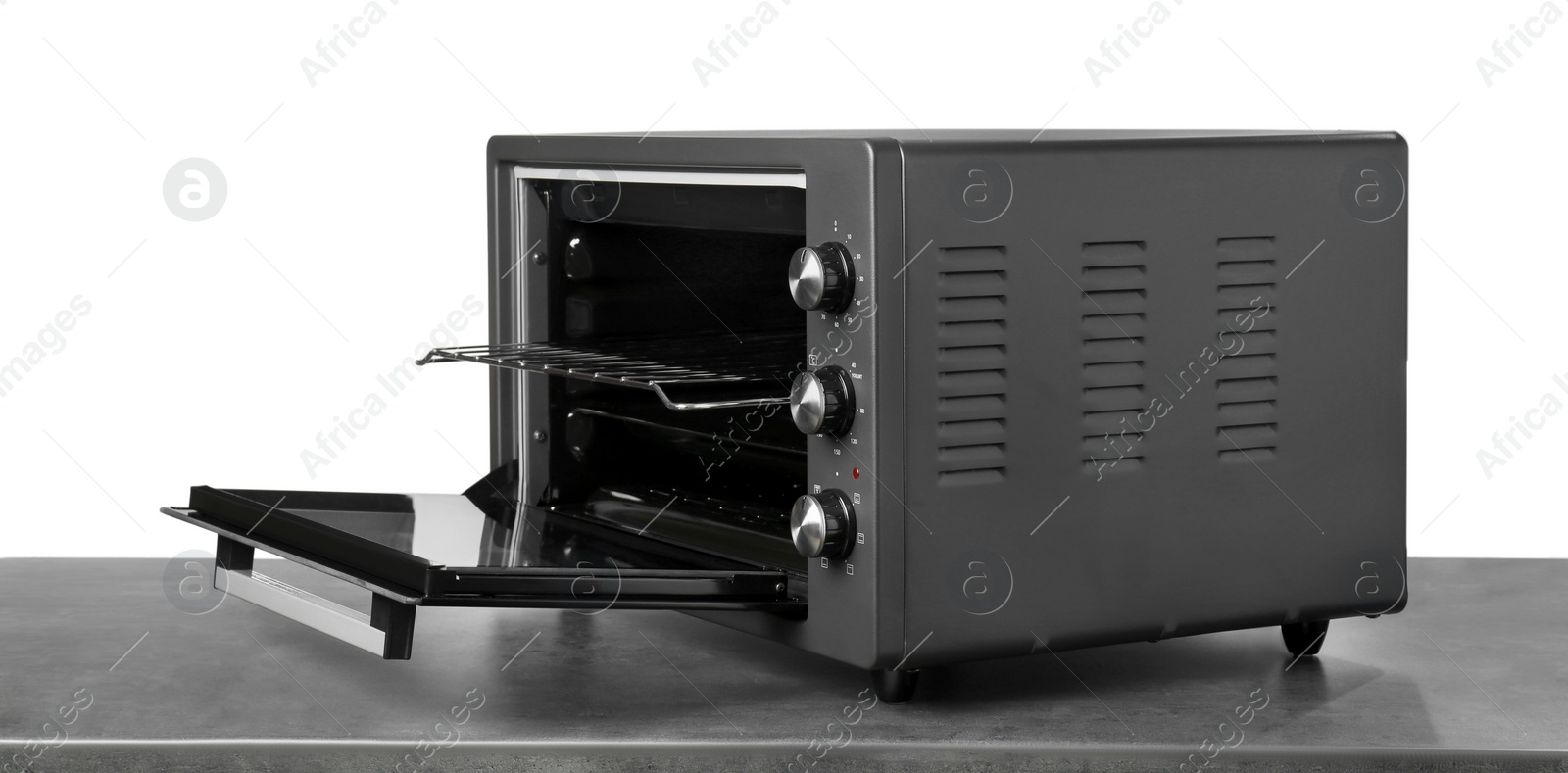 Photo of One electric oven on grey table against white background