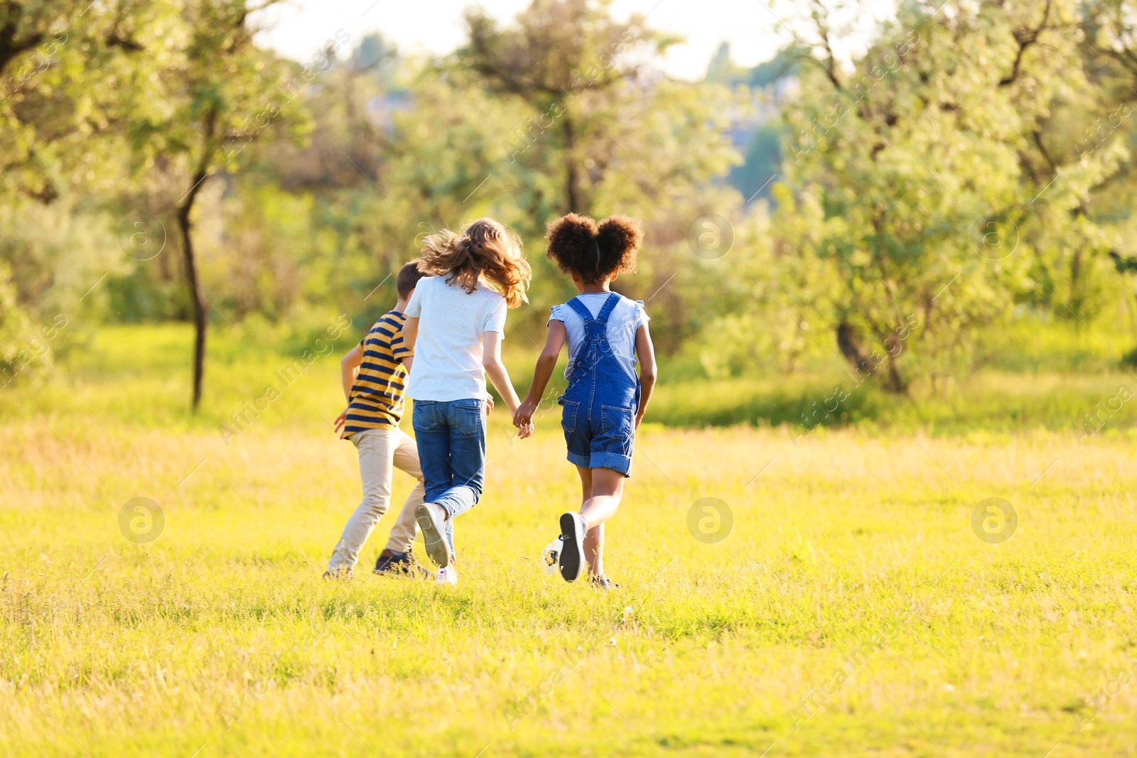 Photo of Cute little children playing with ball outdoors on sunny day