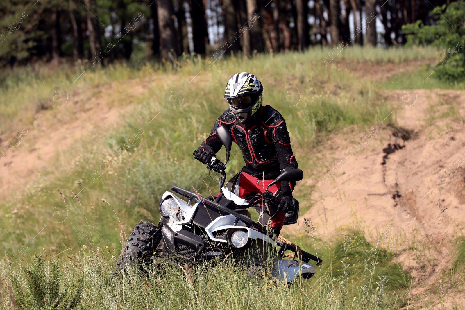 Photo of Man driving modern quad bike on sandy road. Extreme sport