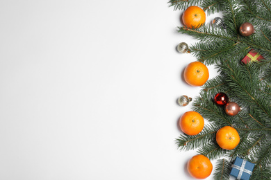 Photo of Flat lay composition with ripe tangerines, fir branches and Christmas decor on white background. Space for text