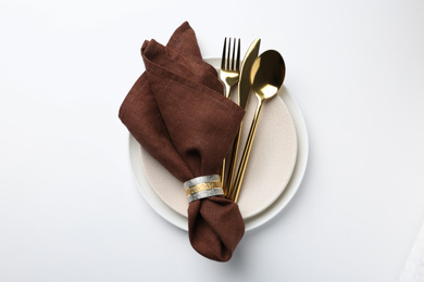 Photo of Stylish elegant cutlery with napkin in plate on white background, top view
