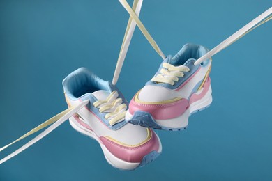 Photo of Pair of stylish sneakers on light blue background