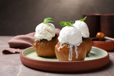 Photo of Delicious baked apples with ice cream and mint served on grey table, space for text