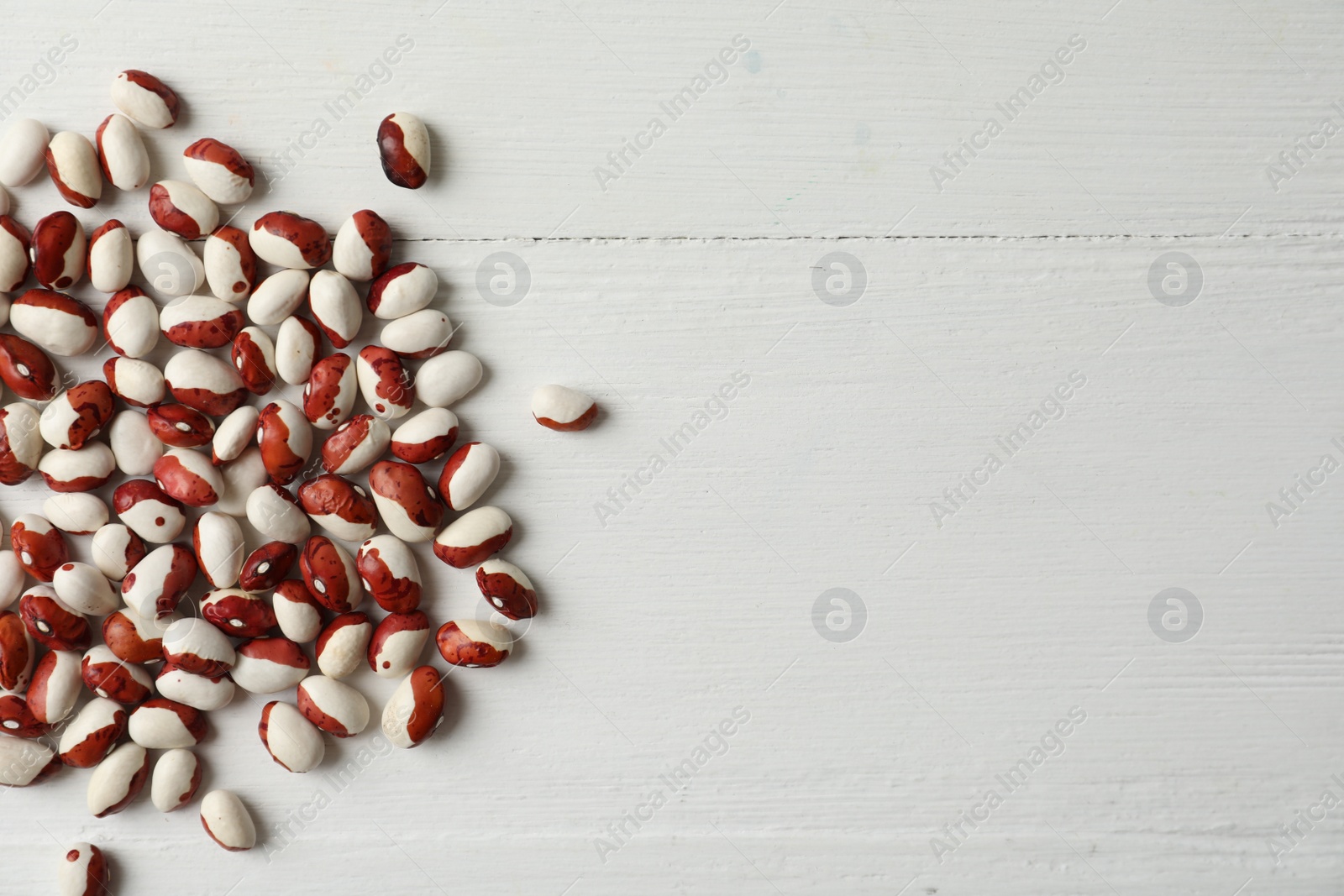 Photo of Raw beans and space for text on white wooden background, flat lay. Vegetable seeds