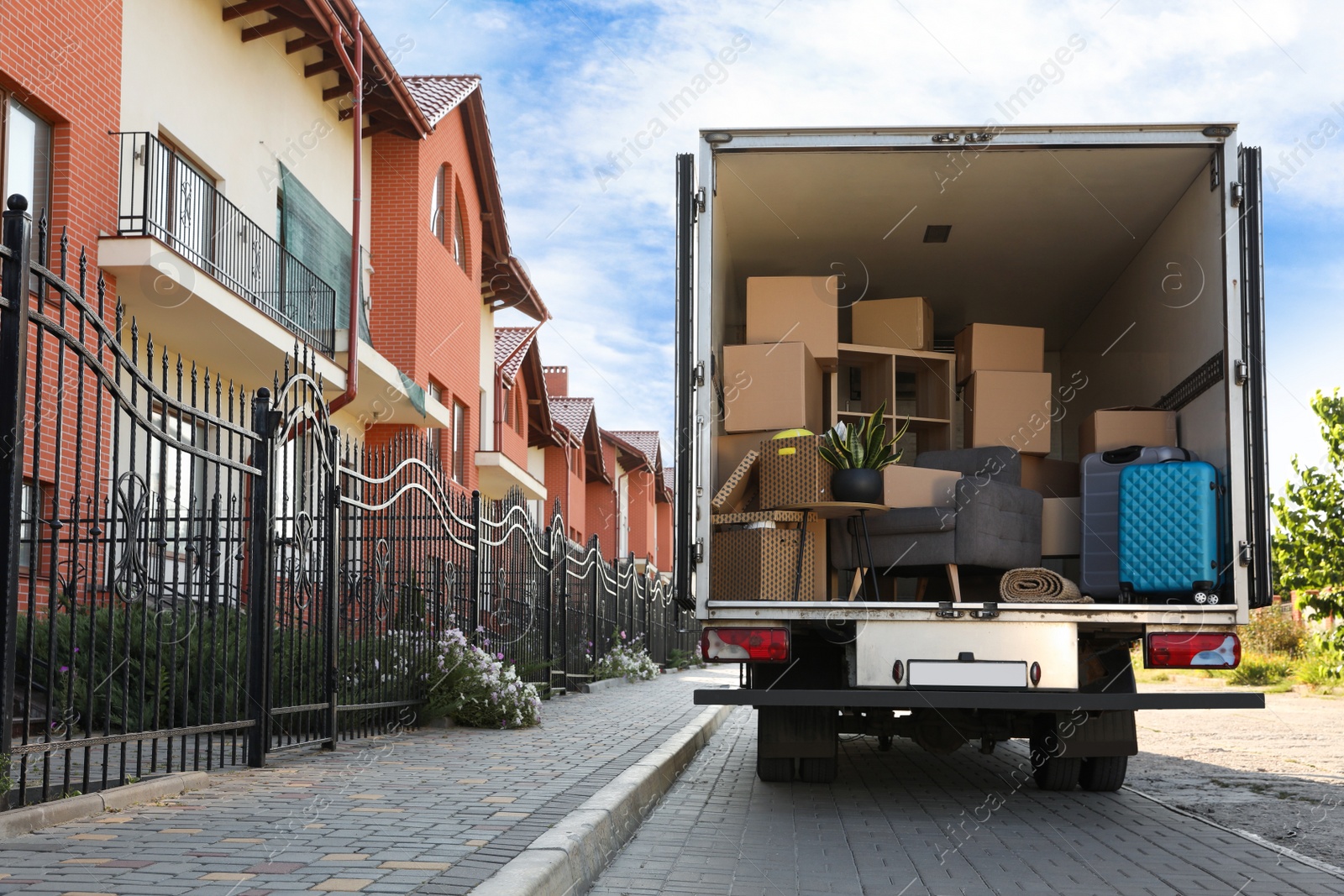 Photo of Van full of moving boxes and furniture near house