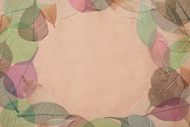 Photo of Frame of beautiful color leaves on beige background, flat lay. Space for text