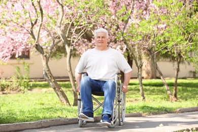 Senior man in wheelchair at park on sunny day