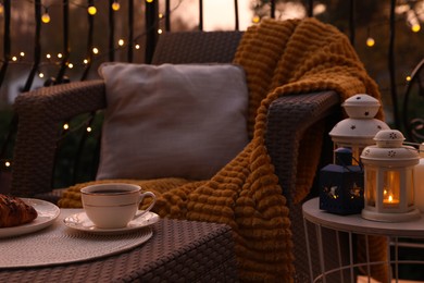 Photo of Beautiful view of garden furniture with pillow, soft blanket and coffee at balcony