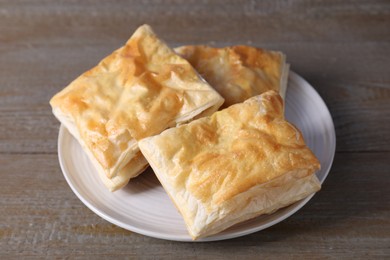 Photo of Delicious fresh puff pastries on wooden table, closeup