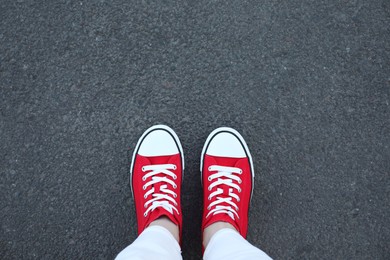 Photo of Woman standing on asphalt, top view. Space for text