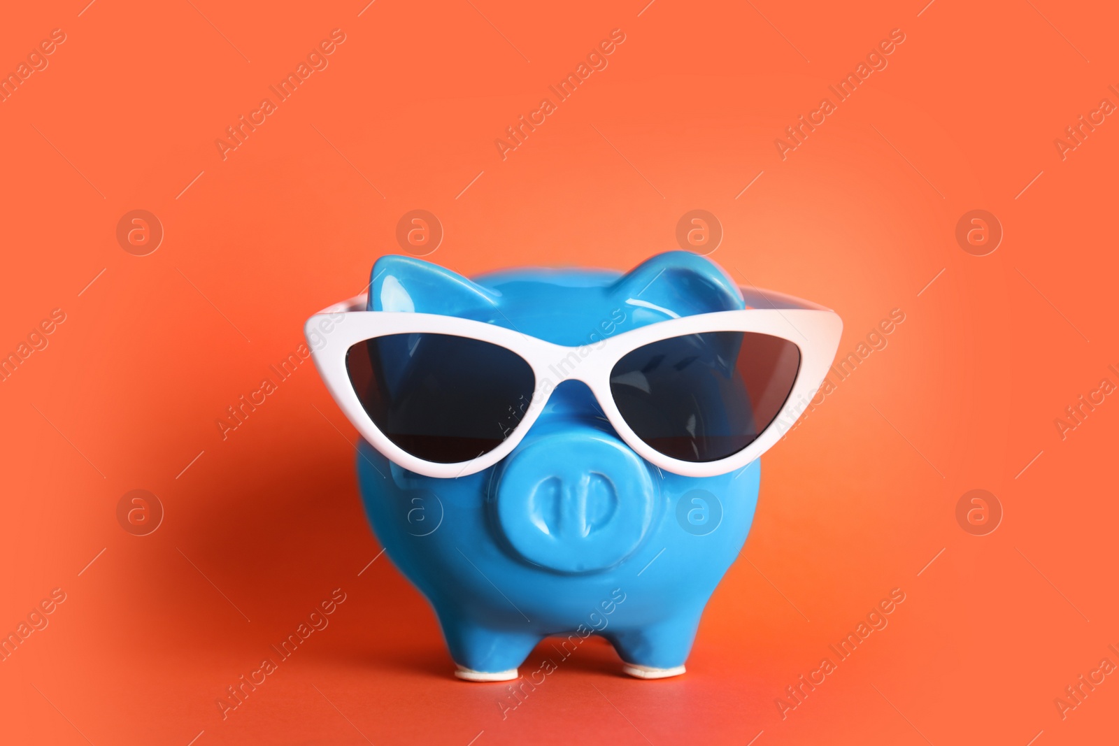 Photo of Piggy bank with sunglasses on color background. Travel agency
