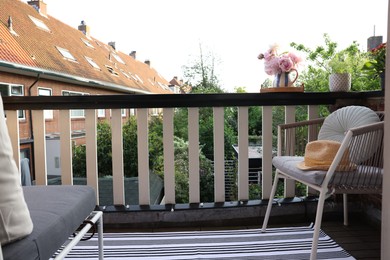 Different plants on railings and chair at cozy balcony outdoors