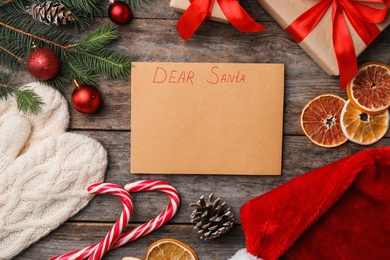 Photo of Flat lay composition with paper and Christmas decor on wooden background. Letter for Santa Claus